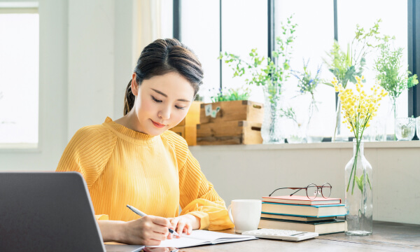 ノートを書く女性